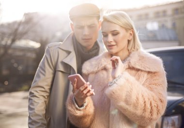 Hoş çift sokakta smartphone kullanarak