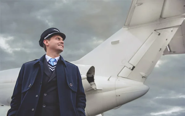 Aviador alegre situándose cerca de aviones — Foto de Stock