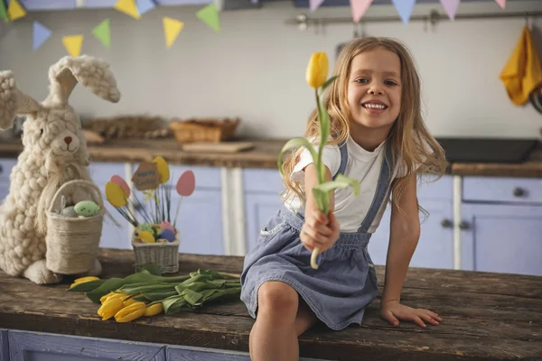 Niño feliz presentando tulipán amarillo —  Fotos de Stock