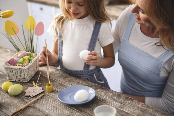 Chica encantada haciendo huevos de colores —  Fotos de Stock