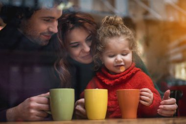 Neşeli aile kafeteryada sıcak içecek içme