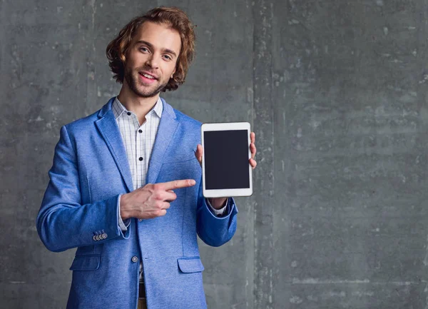 Macho feliz mostrando exibição de tablet eletrônico — Fotografia de Stock