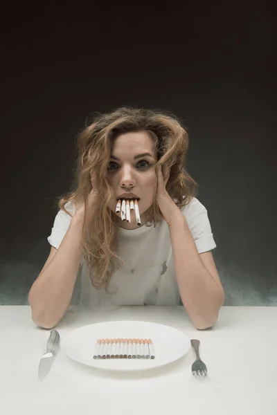 Chica estresada fumando muchos cigarrillos al mismo tiempo — Foto de Stock