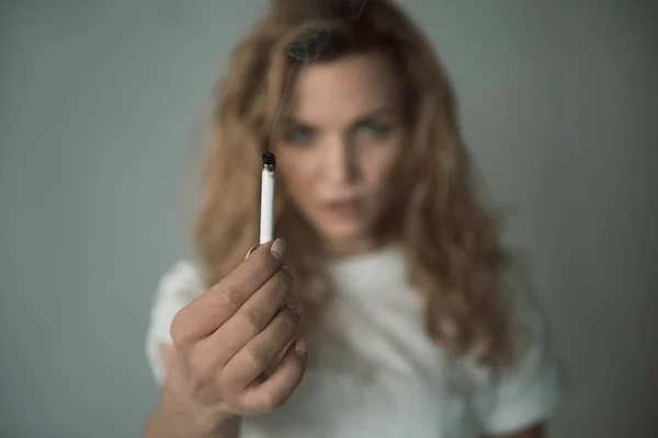 Chica descontenta mostrando cigarrillo caliente — Foto de Stock