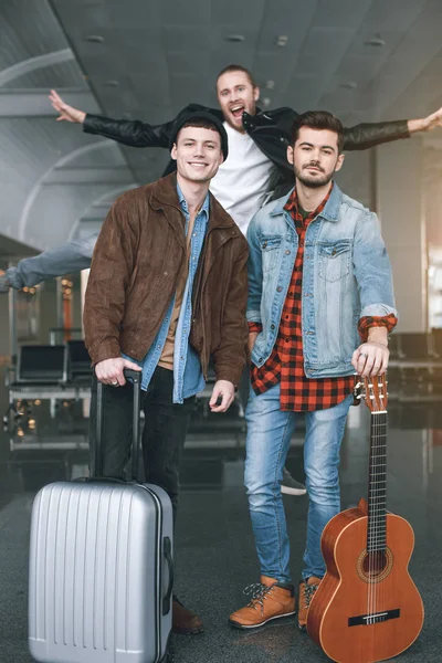 Heureux camarades avec des bagages debout à l'aéroport — Photo