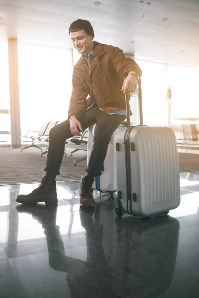 Homme heureux assis sur les bagages — Photo