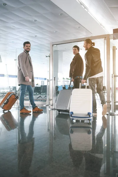 Des amis heureux gardant leurs bagages à l'aéroport — Photo