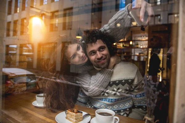 Cheerful young man and woman taking photos on cellphone — Stock Photo, Image