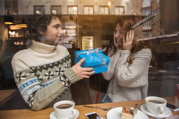 Cheerful loving couple celebrating holiday in cafe — Stock Photo, Image