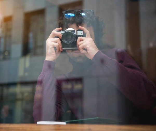 Fundersam ung man fotografera street från fönstret — Stockfoto