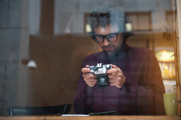 Пенсионер-фотограф, наблюдающий за съемками на камеру
