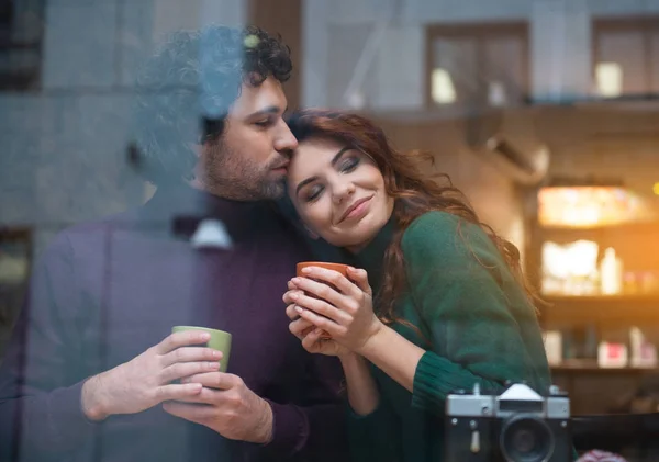 Счастливая любящая пара, обнимающаяся в кафетерии — стоковое фото
