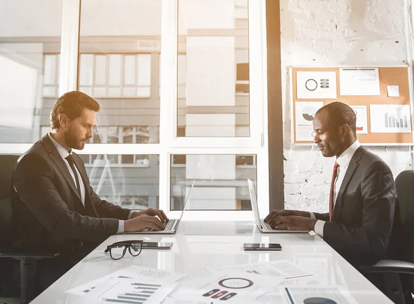 Empresarios agradables están trabajando en computadoras — Foto de Stock