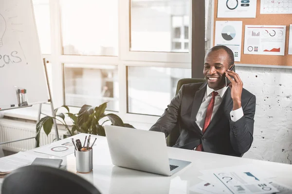 Vrolijke ondernemer heeft aangename gesprek op smartphone — Stockfoto