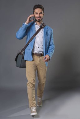 Memnun iddialı genç adam cep telefonu kullanarak