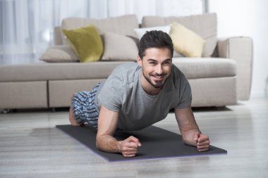 Evde egzersiz yapan memnun adam