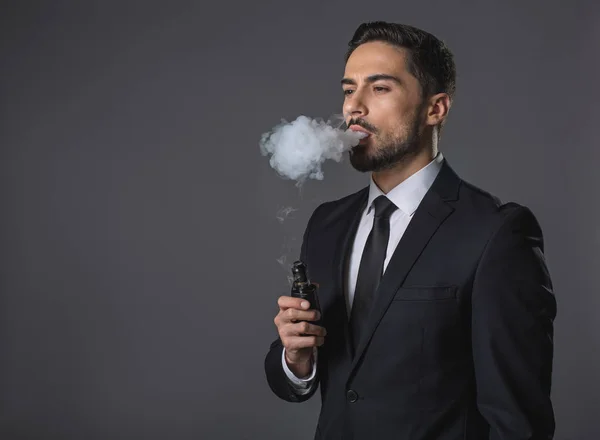 Fiatal töprengő üzletember, elektronikus cigaretta — Stock Fotó