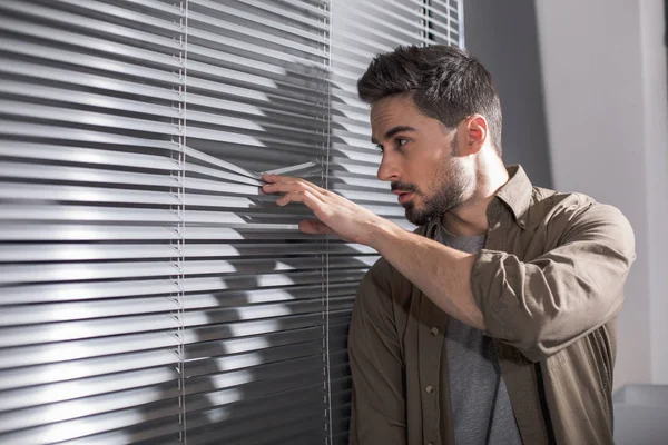 Obrero curioso asomándose por la ventana de la oficina — Foto de Stock