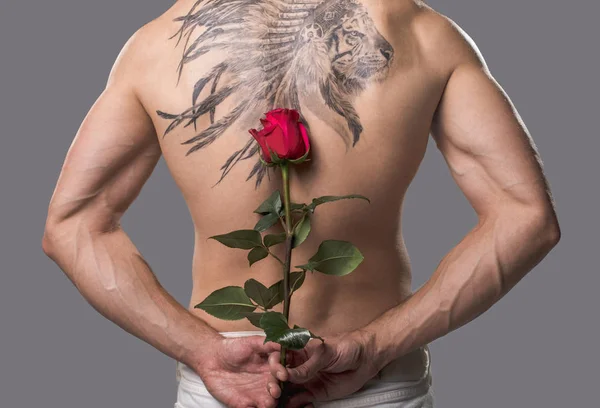 Bare tattooed man hiding flower — Stock Photo, Image