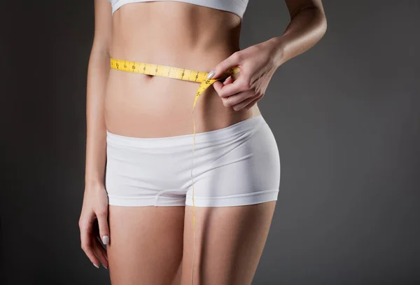 Slim νεαρή γυναίκα λήψη μετρήσεων του waistline — Φωτογραφία Αρχείου