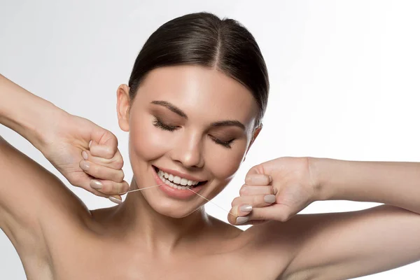 Pretty young woman using special thread for cleaning tooth — Stock Photo, Image