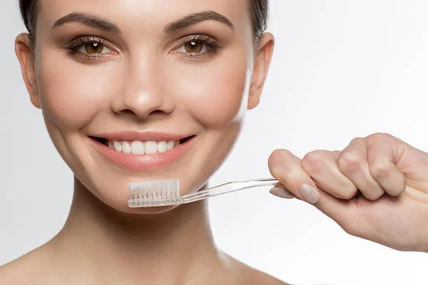 Happy young woman holding toothbrush near her mouth — Stock Photo, Image