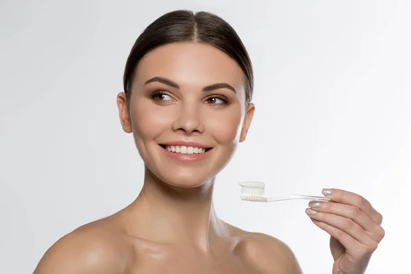 Joyful girl brushing her teeth by special toothpaste — Stock Photo, Image