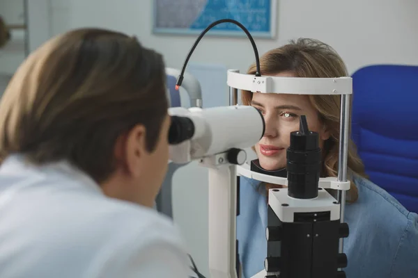 Beaming female examining eyesight with equipment — Stock Photo, Image