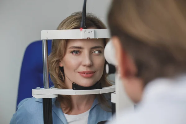 Щаслива жінка оглядає очі в офтальмологічному центрі — стокове фото
