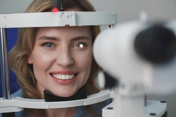 Mujer saliente inspeccionando los ojos en el centro oftalmológico — Foto de Stock