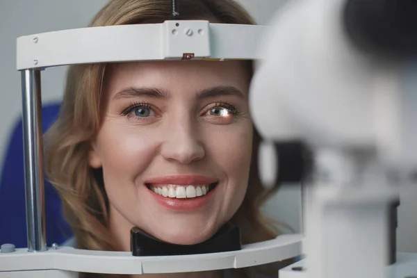 Cheerful lady examining eyesight with equipment — Stock Photo, Image