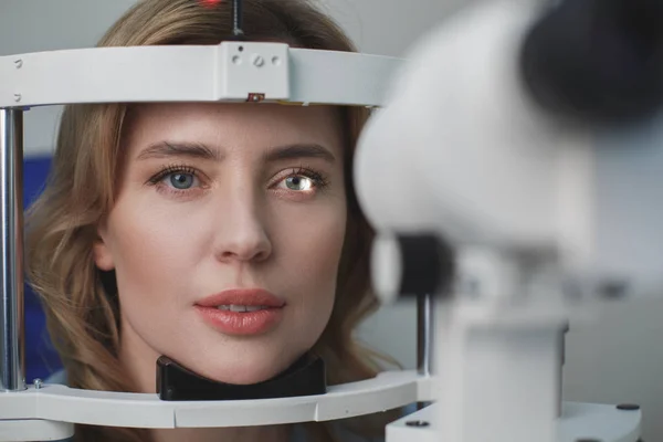 Koncentruje się kobieta sprawdzanie oczy w centrum okulistyczne — Zdjęcie stockowe