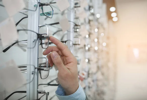 Man arm att välja glasögon för att köpa det. — Stockfoto