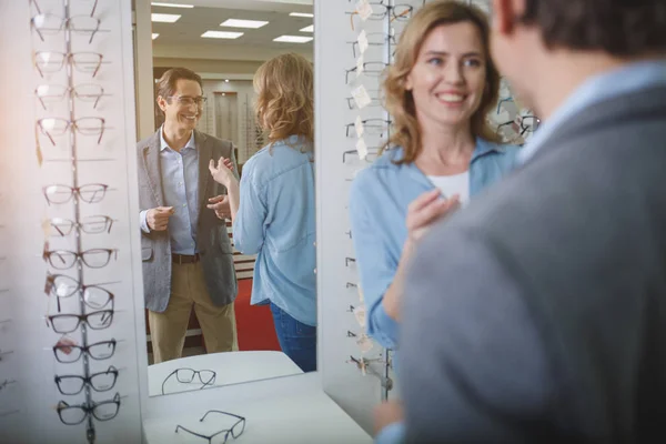 Beaming couple speaking in optician shop — Stock Photo, Image