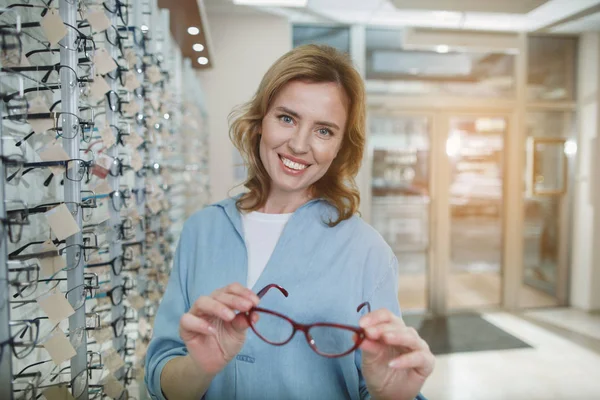 Comprador alegre sosteniendo anteojos en las manos —  Fotos de Stock