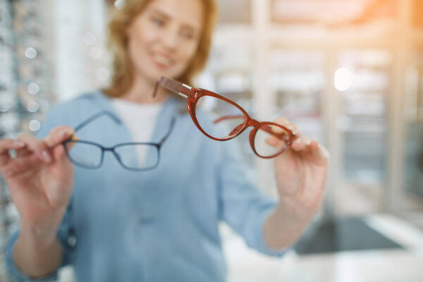 Woman arms holding eyeglasses in glasses shop