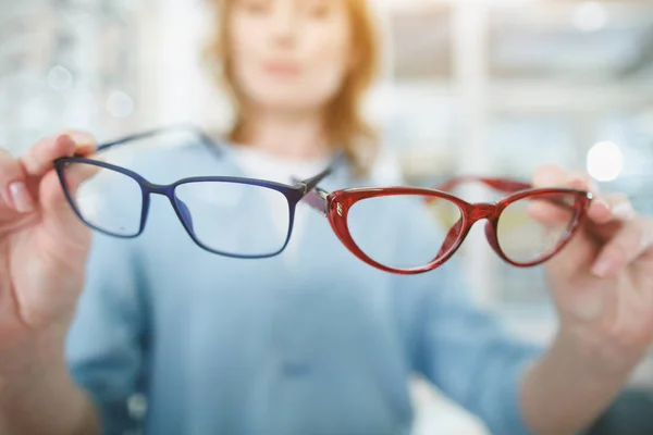 Woman arms keeping spectacles in optical store — Stock Photo, Image