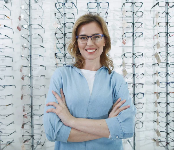 Mujer alegre localizando en tienda óptica — Foto de Stock