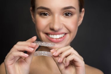 Neşeli kız clear aligner gösterilen