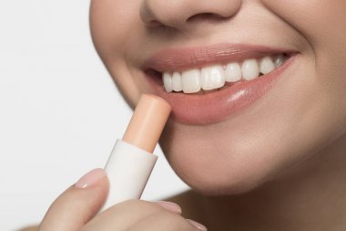 Neşeli genç kadın hijyenik ruj uyguluyor