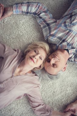 Relaxing pensioners lying on the floor clipart