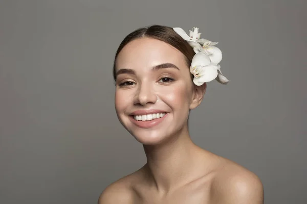 Elegantes Mädchen posiert mit einer Blume im Haar — Stockfoto