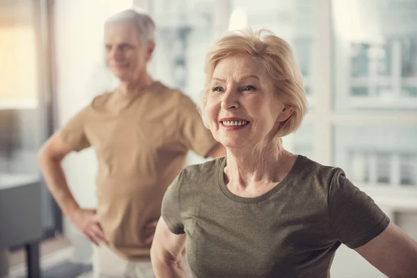 Positive Rentner machen körperliche Übungen im Haus — Stockfoto