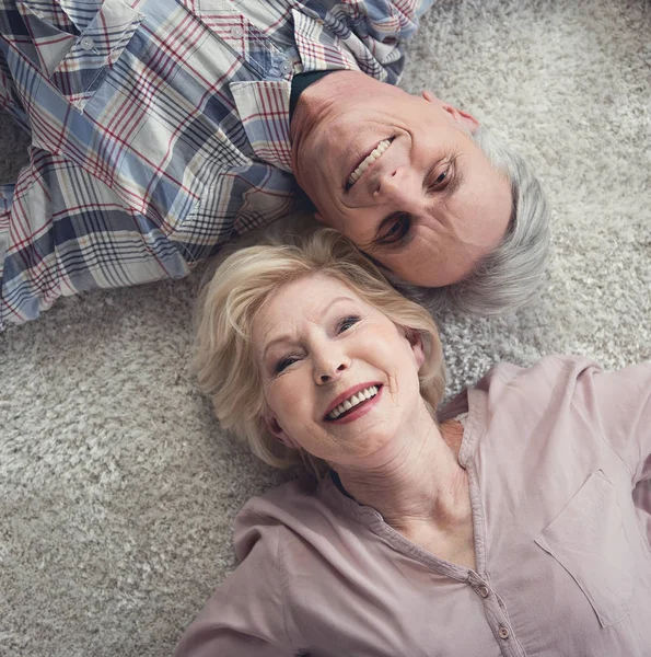 Contenido pensionistas relajándose en la alfombra — Foto de Stock