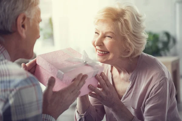 Encantada anciana aceptando regalo del hombre — Foto de Stock