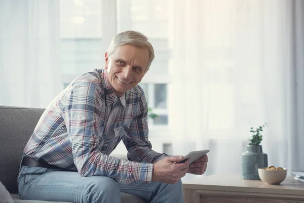 Senior male using gadget with joy at home — Stock Photo, Image