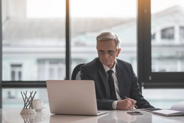 Fokuserade pensionera manliga arbetare att skriva i gadget — Stockfoto