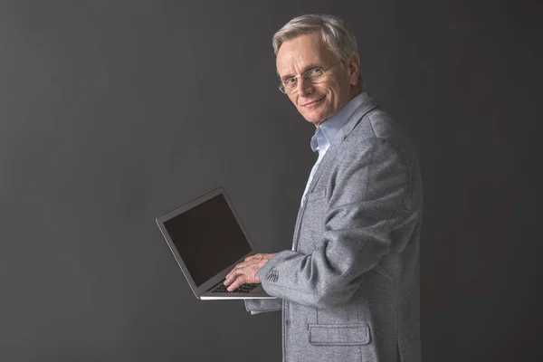 Fröhlicher Rentner zeigt Bildschirm seines Laptops — Stockfoto