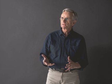 Dalgın yaşlı adam gesticulating eller