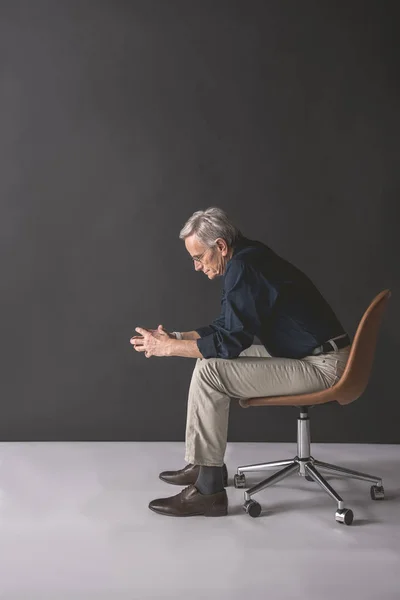 Пенсионер, сидящий на сиденье — стоковое фото